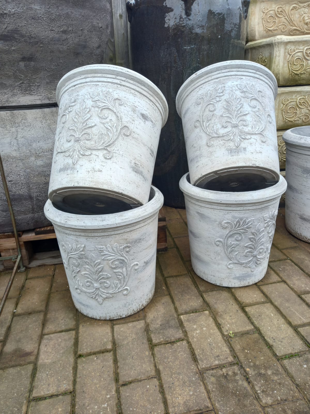 White decorative planters with floral motifs